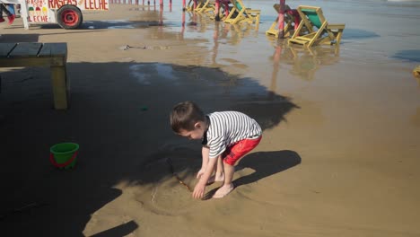 a small boy playing on the beach