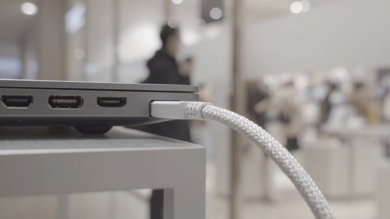 Close-up of a Laptop's Connection Port with a USB-C Cable Plugged In, Showcasing Modern Technology in a Minimalist Retail Environment