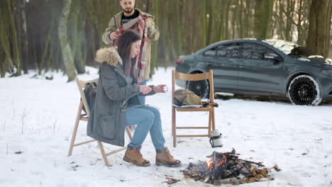 caucasian couple camping in a snowed forest.