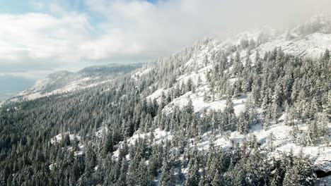 beautiful scene of snow covered mountains and forests in the nicola valley on a cloudy day in the winter with sunshine close to merritt, bc canada