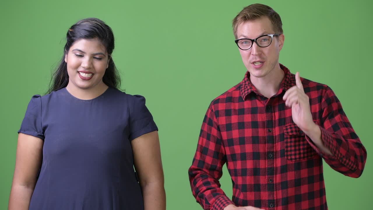 joven pareja de negocios multiétnica juntos contra un fondo verde