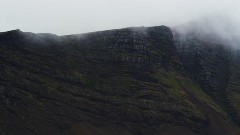 Misty-dark-color-mountains-in-Iceland,-zoom-out,-static-view