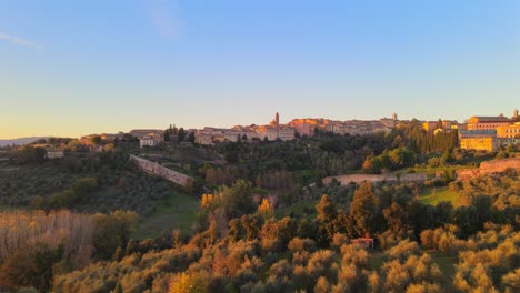 Klassischer-Blick-Aus-Der-Luft-Auf-Die-Mittelalterliche-Stadt-San-Gimignano-Und-Die-Toskanische-Landschaft-Im-Abendlicht