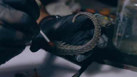 painting workshop man painting 3d printed horns with a brush close up shot