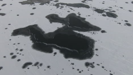 lago congelado desde arriba con patrones en blanco y negro de hielo