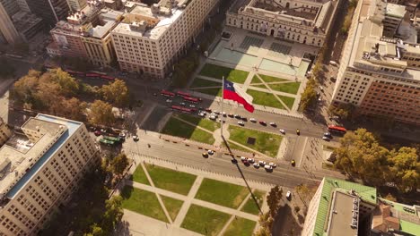 slow motion aerial of the bandera bicentenario, a monumental chilean flag waving proudly along a busy avenue in de chile, along with city traffic.