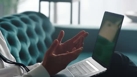 businessman having video chat on laptop. professional gesturing hands at camera