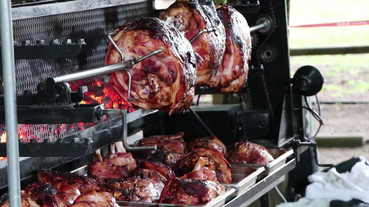 Carne che gira sullo spiedo, con braci ardenti dietro