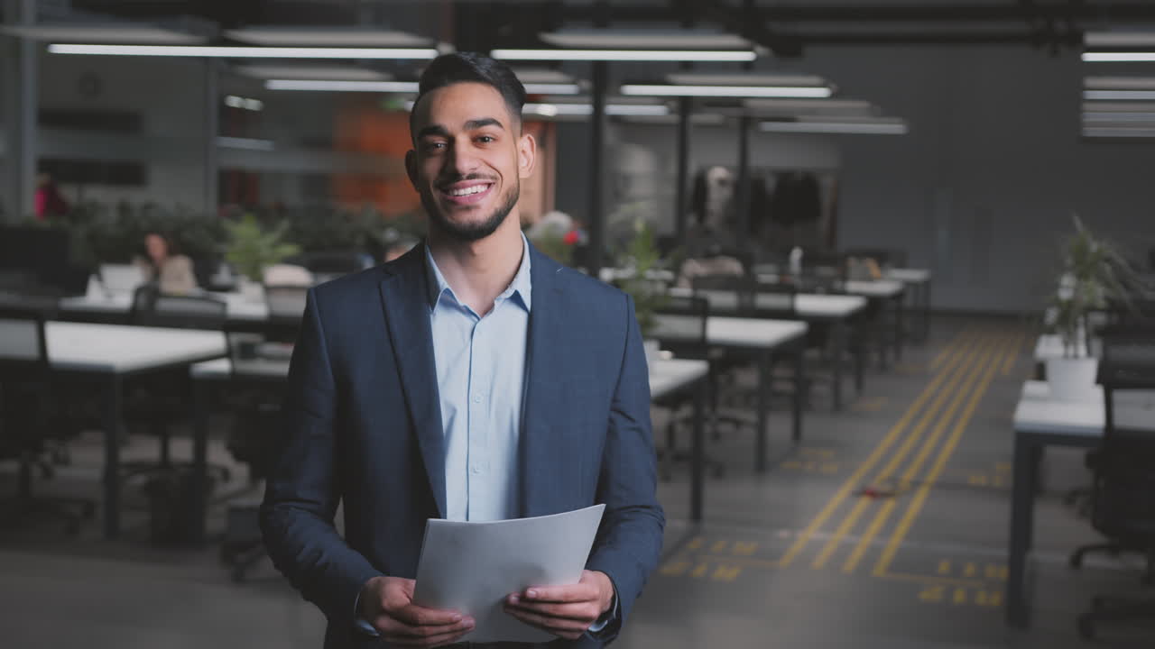 Businessman Holding Documents in Modern Office