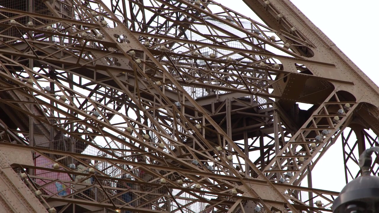 A static low angle shot captures the complex metal structure against a bright sky