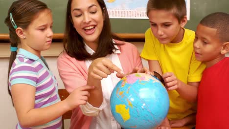 Teacher-and-pupils-looking-at-globe-