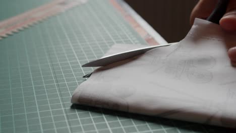 cutting through fabric on a table with scissors.