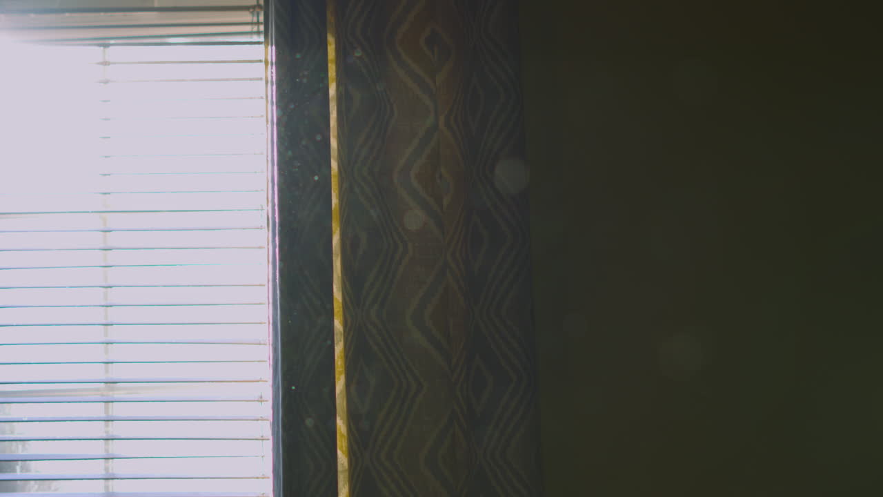Dust Particles Floating Slowly in the Air Through Bright Sunlight Window with Curtains and Blinds. Heavenly Home Lighting. ProRes 4K.