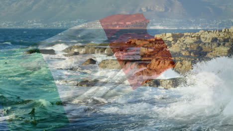 composición digital de ondear la bandera de italia contra las olas del mar que golpean las rocas