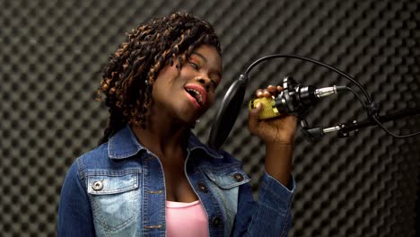 african american alfro hair black woman sing a song loudly and express feeling with power sound over hanging microphone condenser