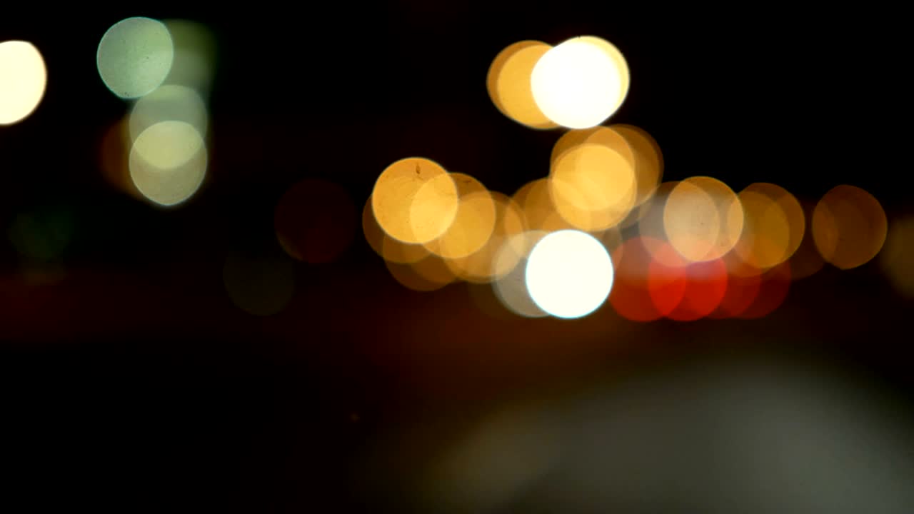 conducir un coche a través de la carretera de la noche, la autopista. luces desenfocadas calle de los ángeles resumen. ciudad fondo borroso. movimientos círculos bokeh de tráfico nocturno.