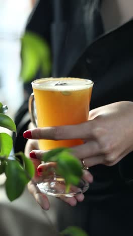 woman holding a spiced orange drink