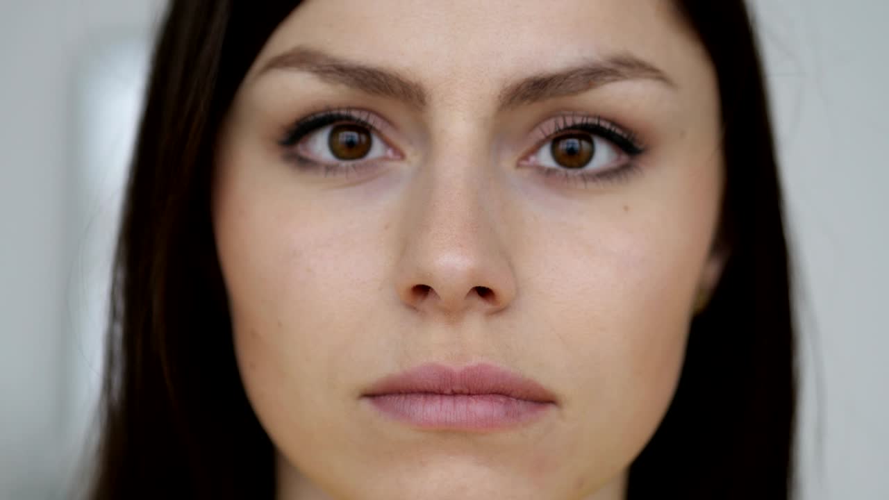 cerca de la cara seria de una mujer joven mirando a la cámara