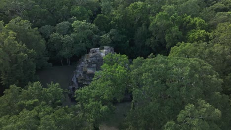 reveal shot of old mayan ruins at yaxha in middle of jungle, aerial