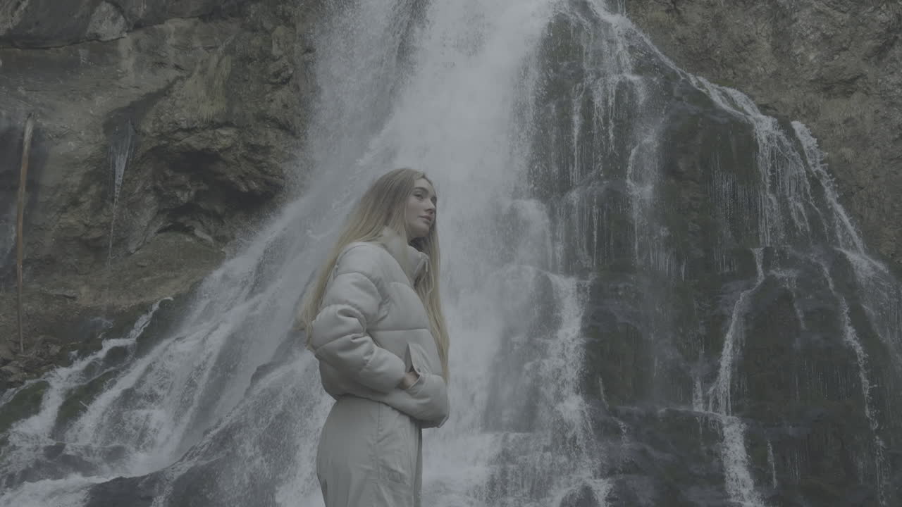 Woman standing by a waterfall in nature