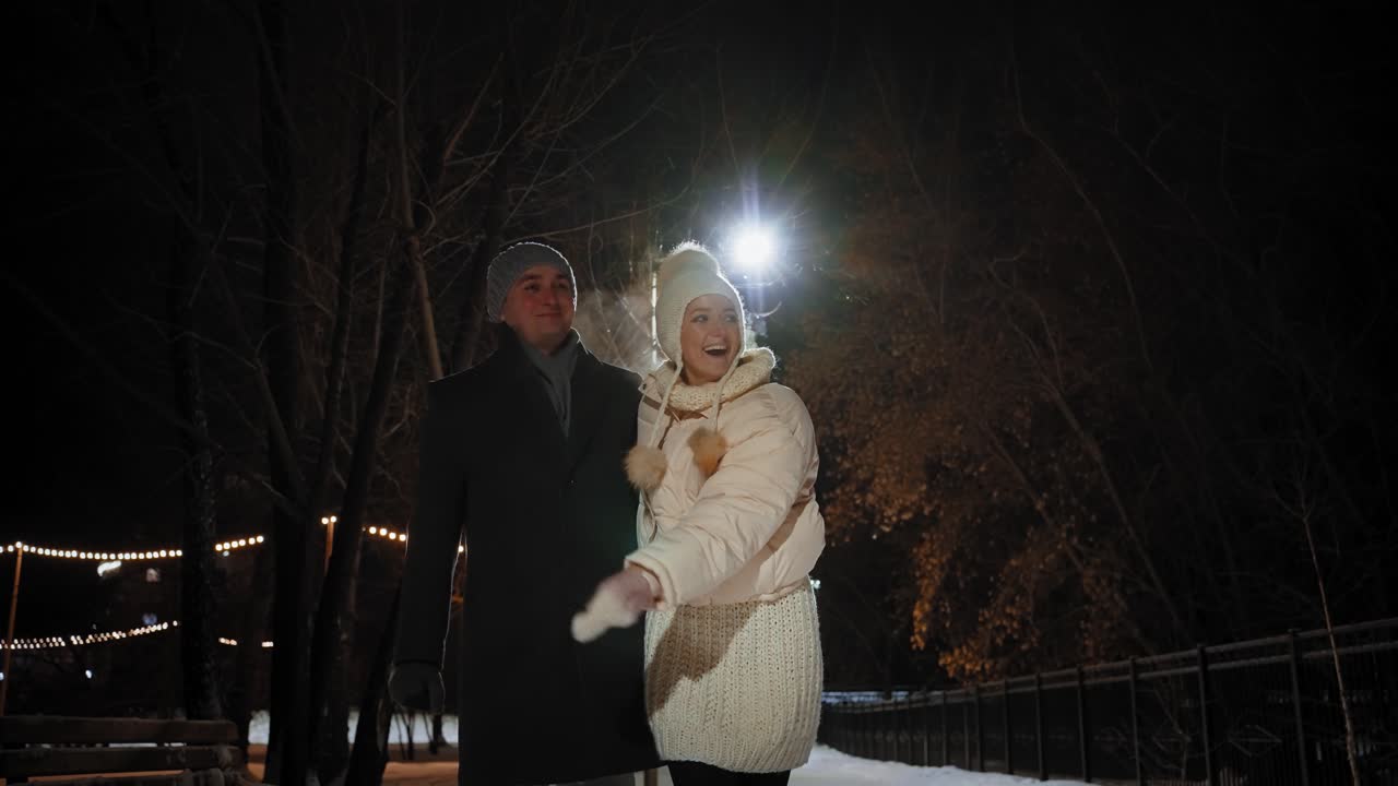 Couple Walking in a Snowy Park at Night