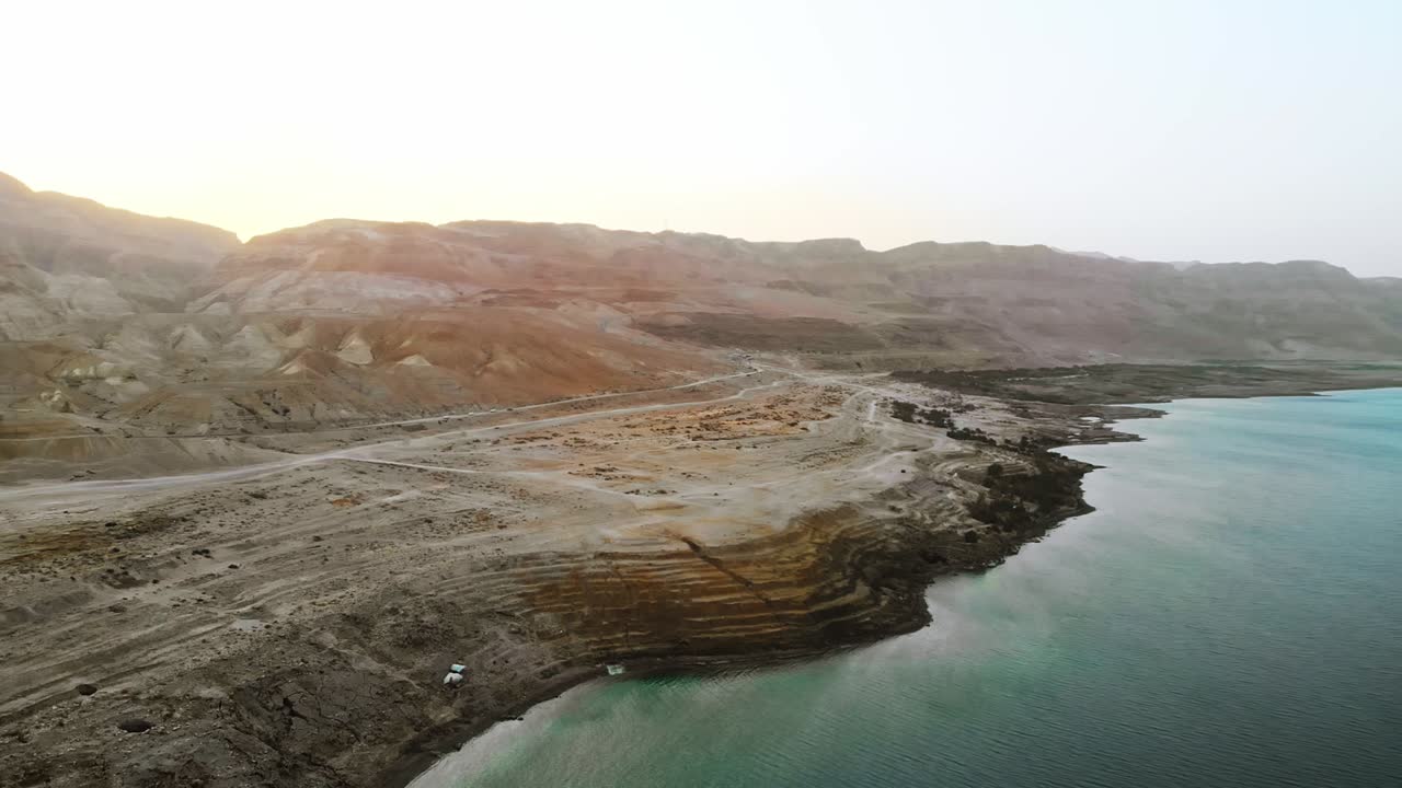 Vista drone 4k del Mar Morto, volo sopra il lago salato con la strada in vista.