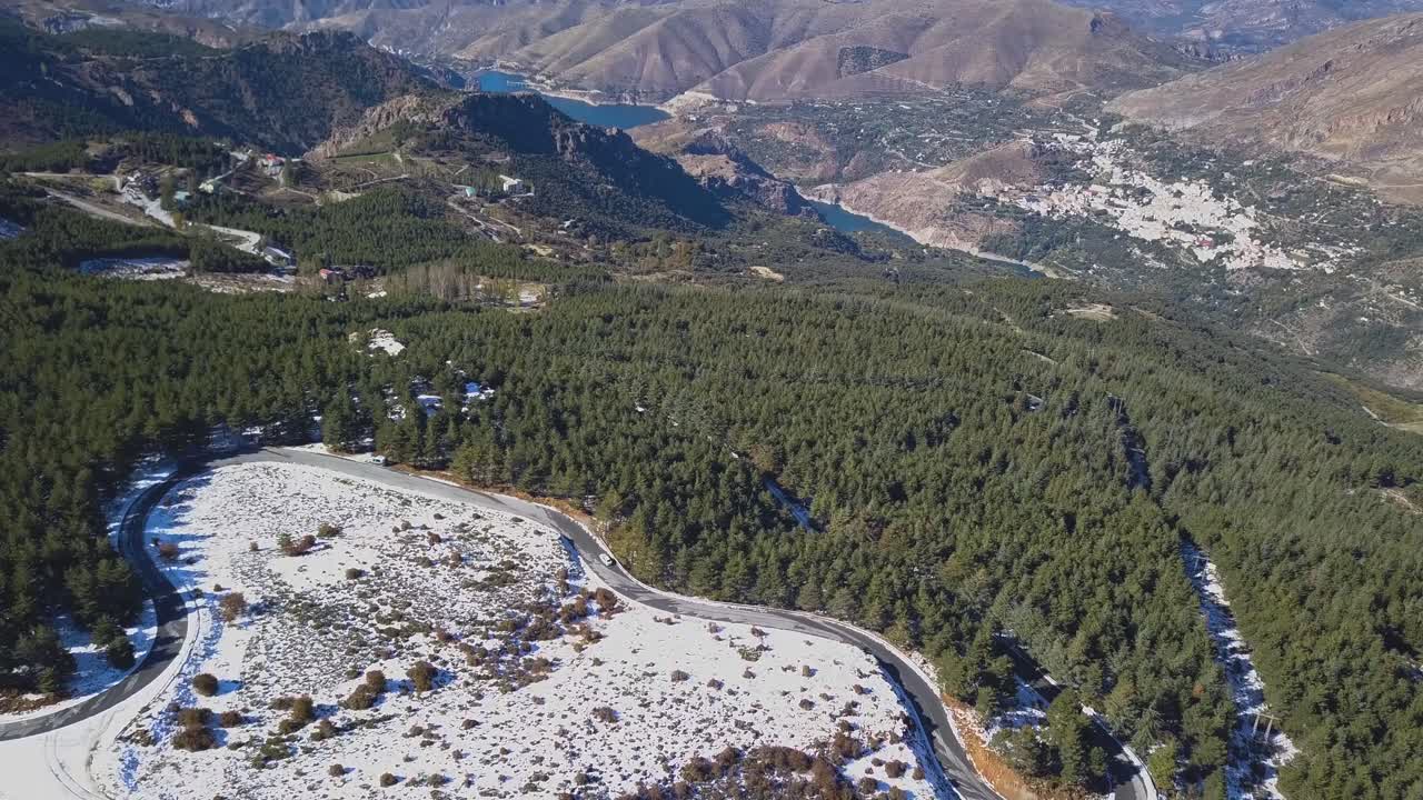vista aérea de la carretera en las montañas nevadas y un camión conduciendo por esa carretera