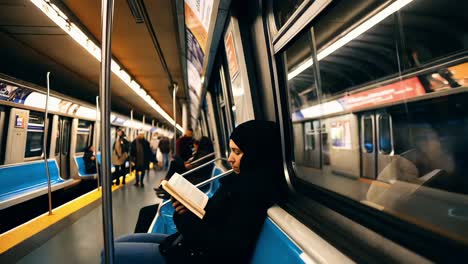 woman reading a book on a subway