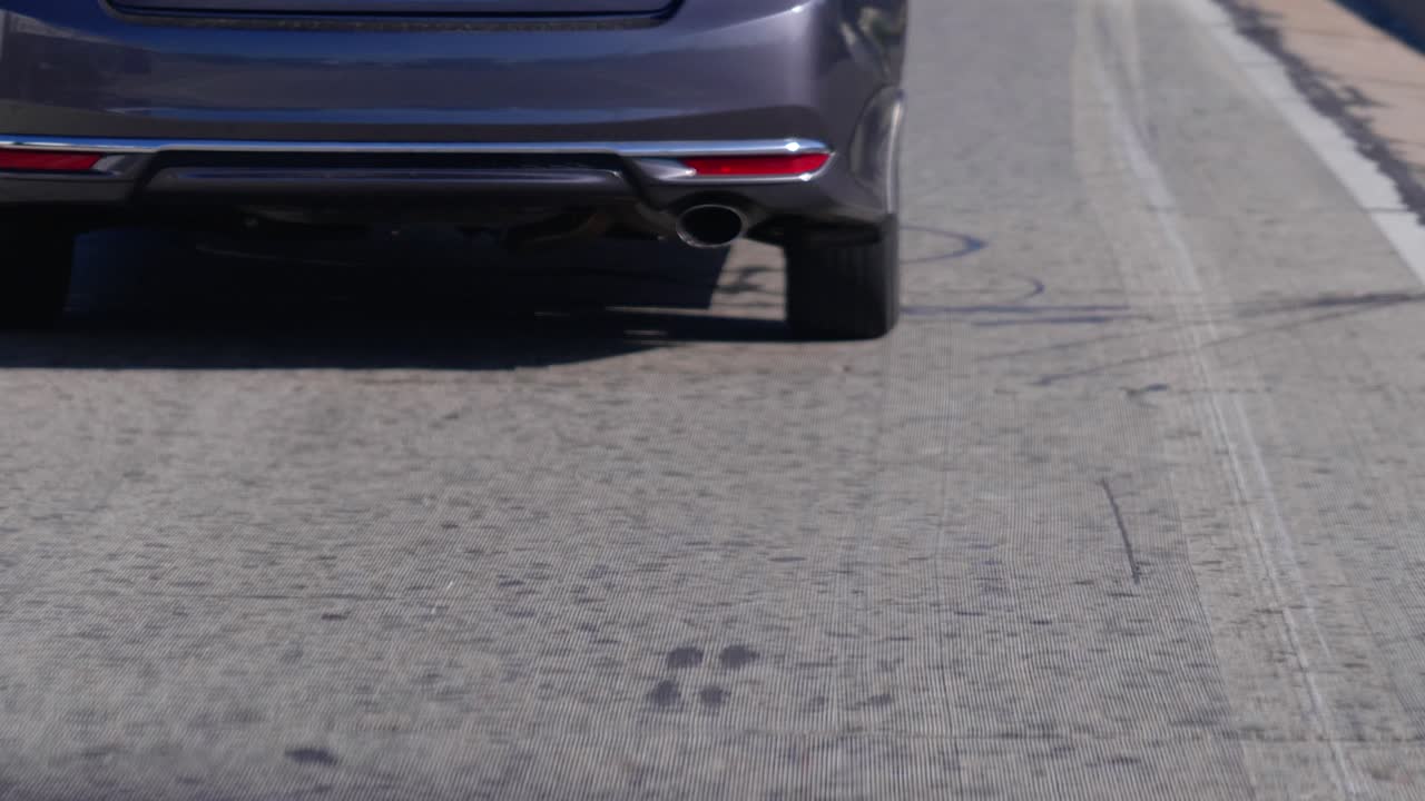 천천히 움직이는 자동차의 자동차 타이어와 테일 파이프