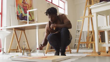 Artista-Masculino-Afroamericano-Con-Delantal-Pintando-Sobre-Lienzo-En-El-Estudio-De-Arte