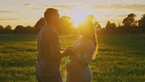 pregnant couple at sunset
