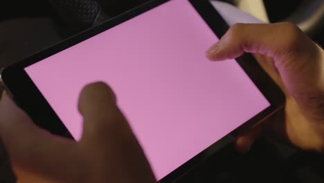 person using a tablet in a car at night