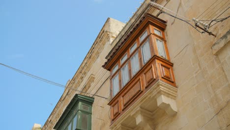 facade of a building with typical wooden bow window in historic center of birgu in malta