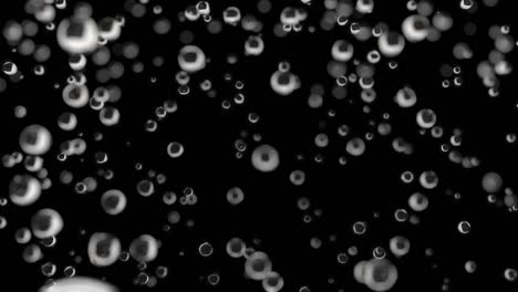 water droplets are falling in slow motion on a dark background.