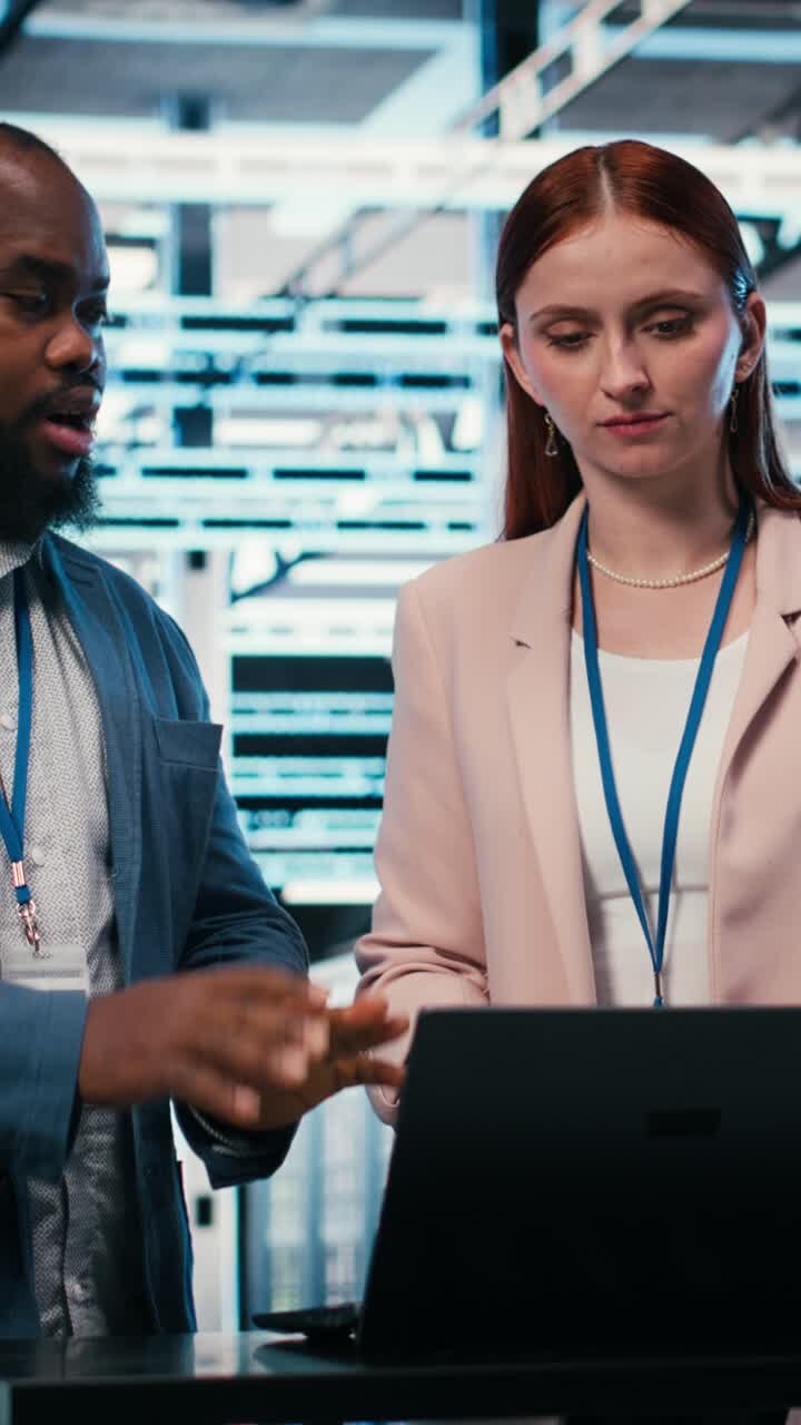 Video verticale: Colleghi di un data center che collaborano per gestire soluzioni IT di cloud computing.