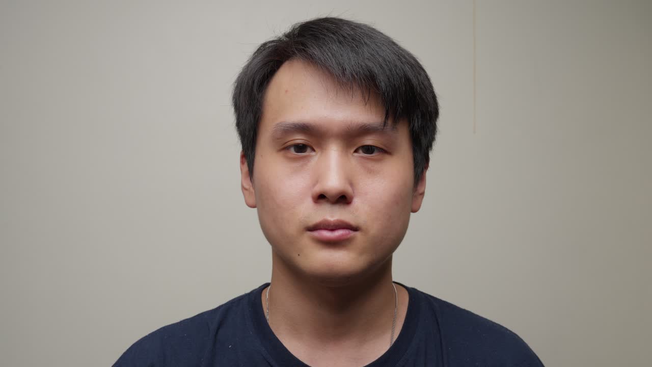 "아름다운 젊은 중국인이 미소 짓기 시작하고 손으로 ""좋아""라는 표시를 합니다."