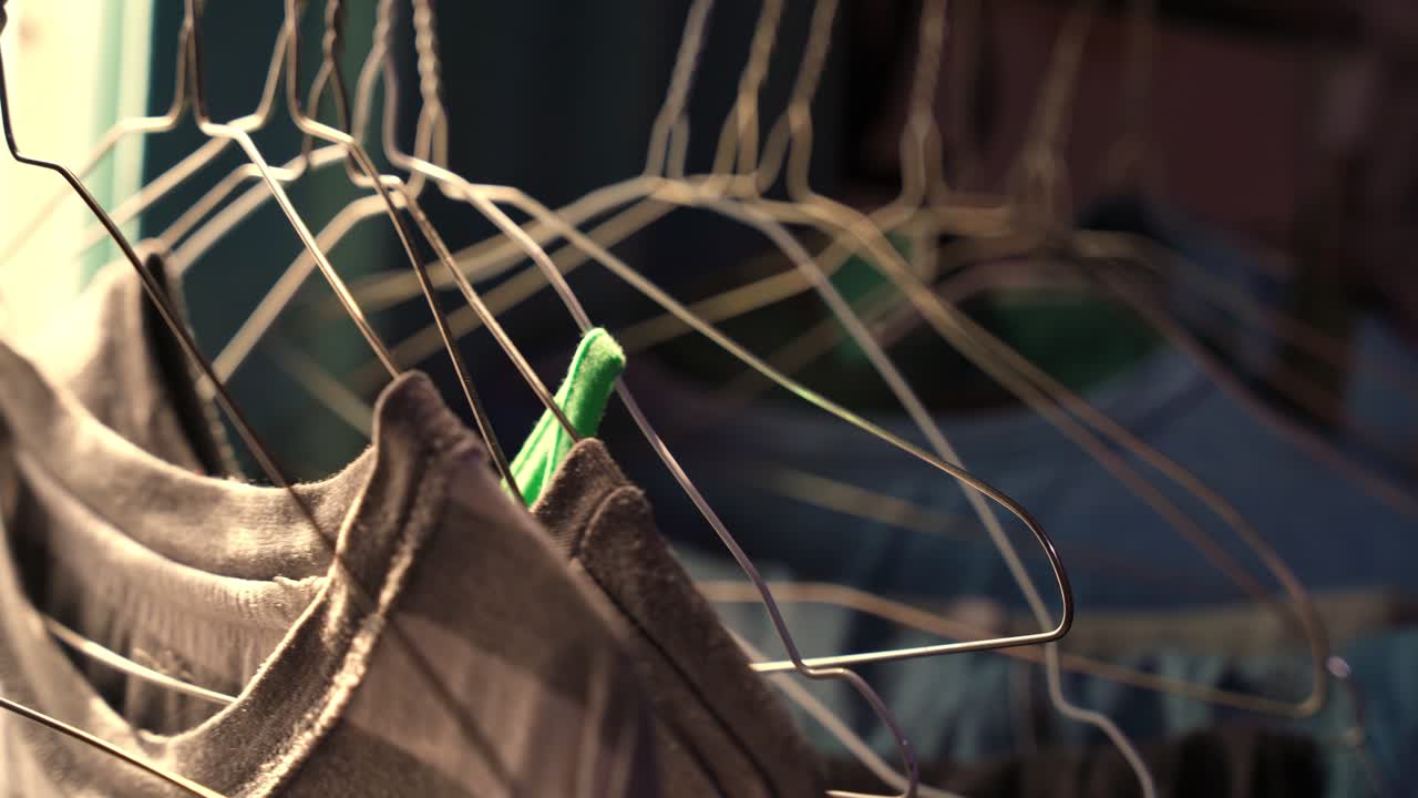 Close-up of a striped shirt hanging on a wire hanger, bathed in soft natural light—ideal for lifestyle or fashion edits