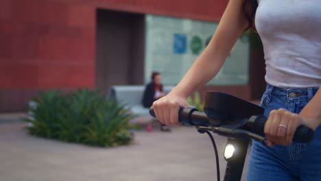 asian woman drive electric bike outdoors. fast ride on scooter in modern city.