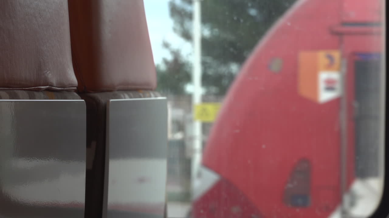 Villefranche sur Mer, France - March 24, 2025: View of the back of the window seats on a train passing by a station