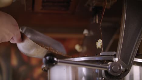 Woman-pouring-corn-kernels-in-popcorn-machine.-Process-of-popcorn-production