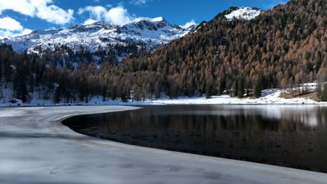 Low-Drone-cruising-flight-on-Malghette's-Lake-in-front-of-Dolomites-at-Fall---not-graded