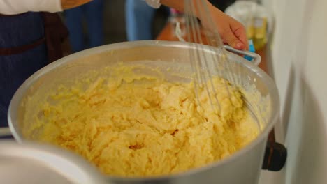 mixing a large pot of mashed cassava from roots harvested on organic farms in the amazon rainforest