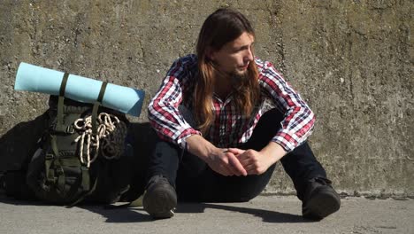 man tourist backpacker sitting on stone wall outdoor 4k