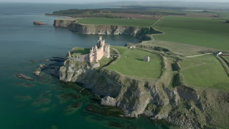 an aerial view of the side and front of tantallon castle ruin on a sunny day, east lothian, scotland