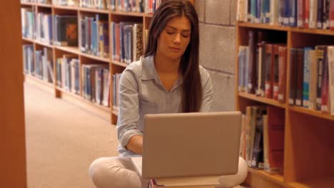 estudiante silencioso usando una computadora portátil en la biblioteca