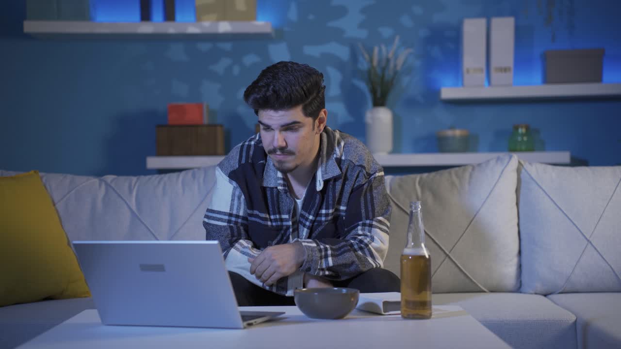 Saddened by the movie, the young man drinks alcohol.