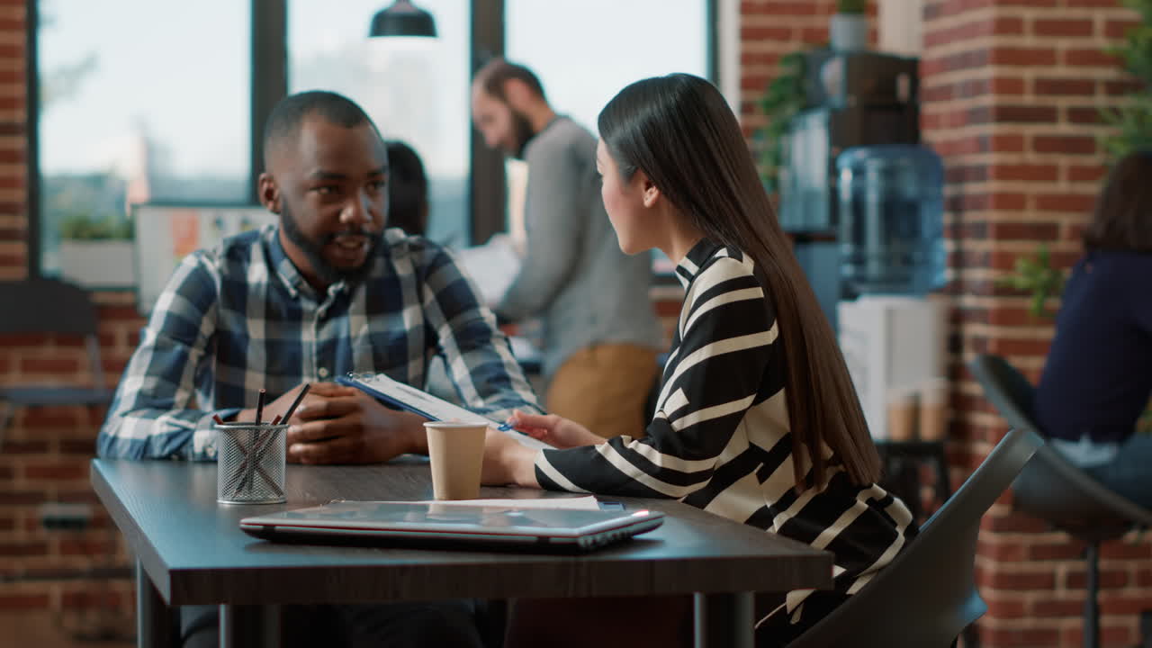 Asian woman interviewing male candidate at recruitment meeting