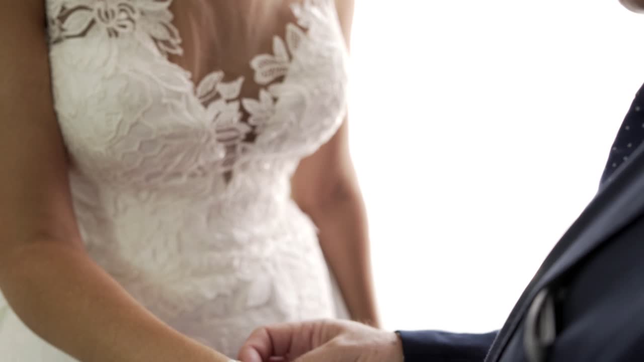 Dama de honor ayuda a la novia a ponerse una pulsera en el día de la boda