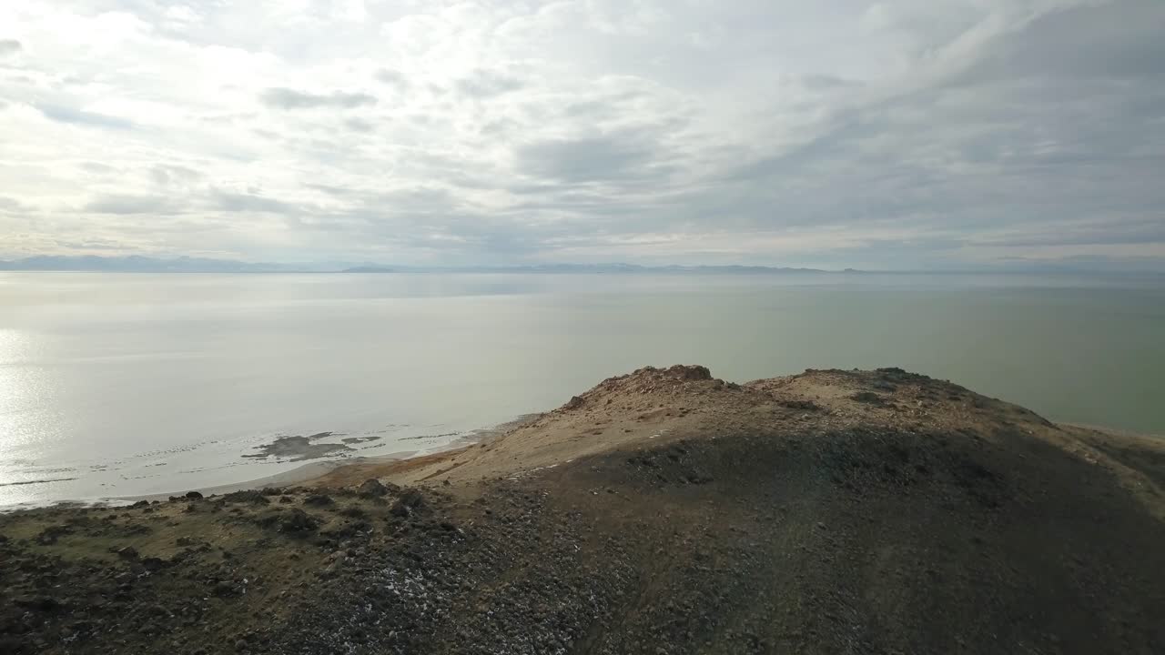 A drone explores the mysterious rocky coastline of Antelope Island in The Great Salt Lake of Utah on a cold, winter evening