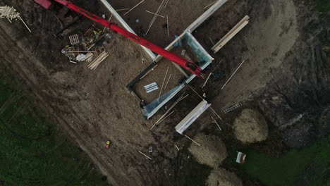 Construction-Workers-And-Mobile-Crane-At-Building-Site-On-Rural-Landscape